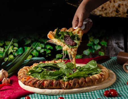 Delicious fresh pizza slice with greens being served, perfect for food lovers.